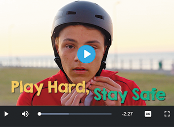 A boy fastens a helmet with the text Play Hard, Stay Safe