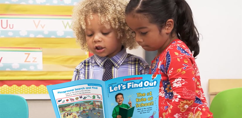 Two children read a Scholastic Let's Find Out magazine together in a classroom