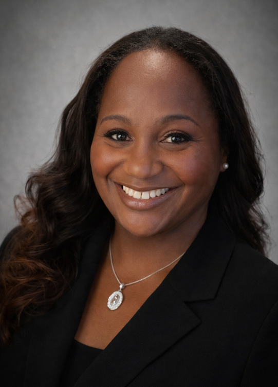 A woman faces the camera in a professional headshot portrait