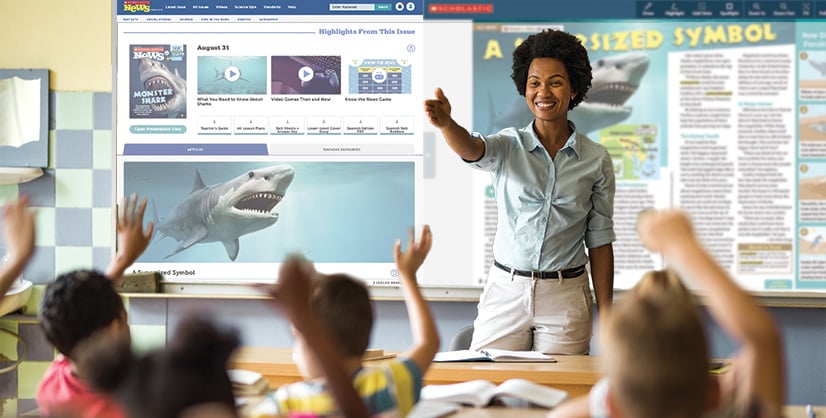 A woman leads a classroom lesson as students raise their hands toward a digital whiteboard